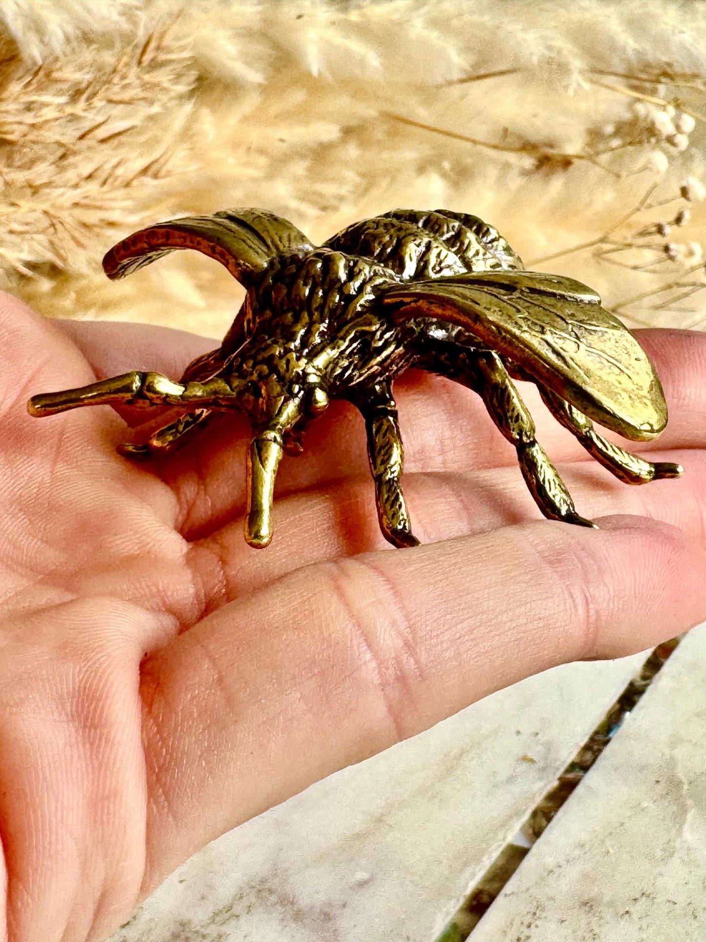 Solid brass bumblebee figurine, realistic bee sculpture, insect ornament, detailed brass garden pollinator paperweight.