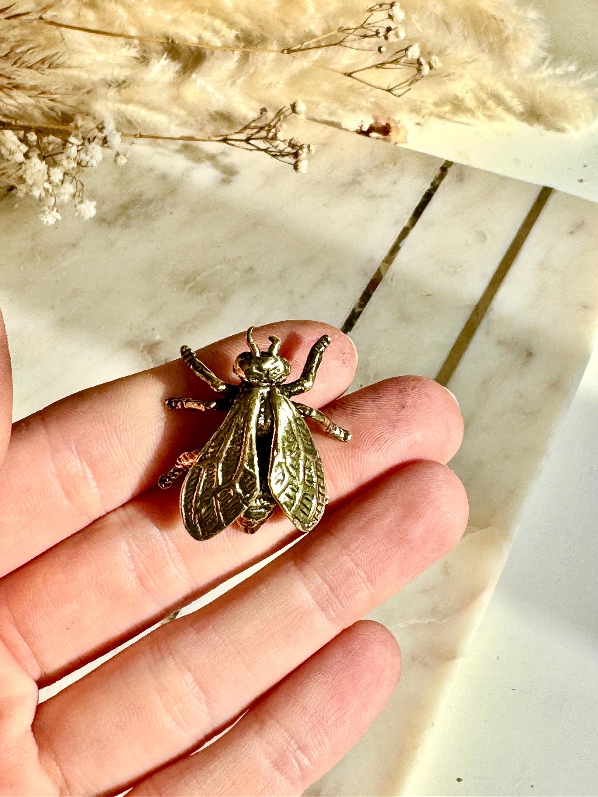 Solid brass bee figurine, realistic fly sculpture, metal insect ornament, detailed brass flying bug paperweight.