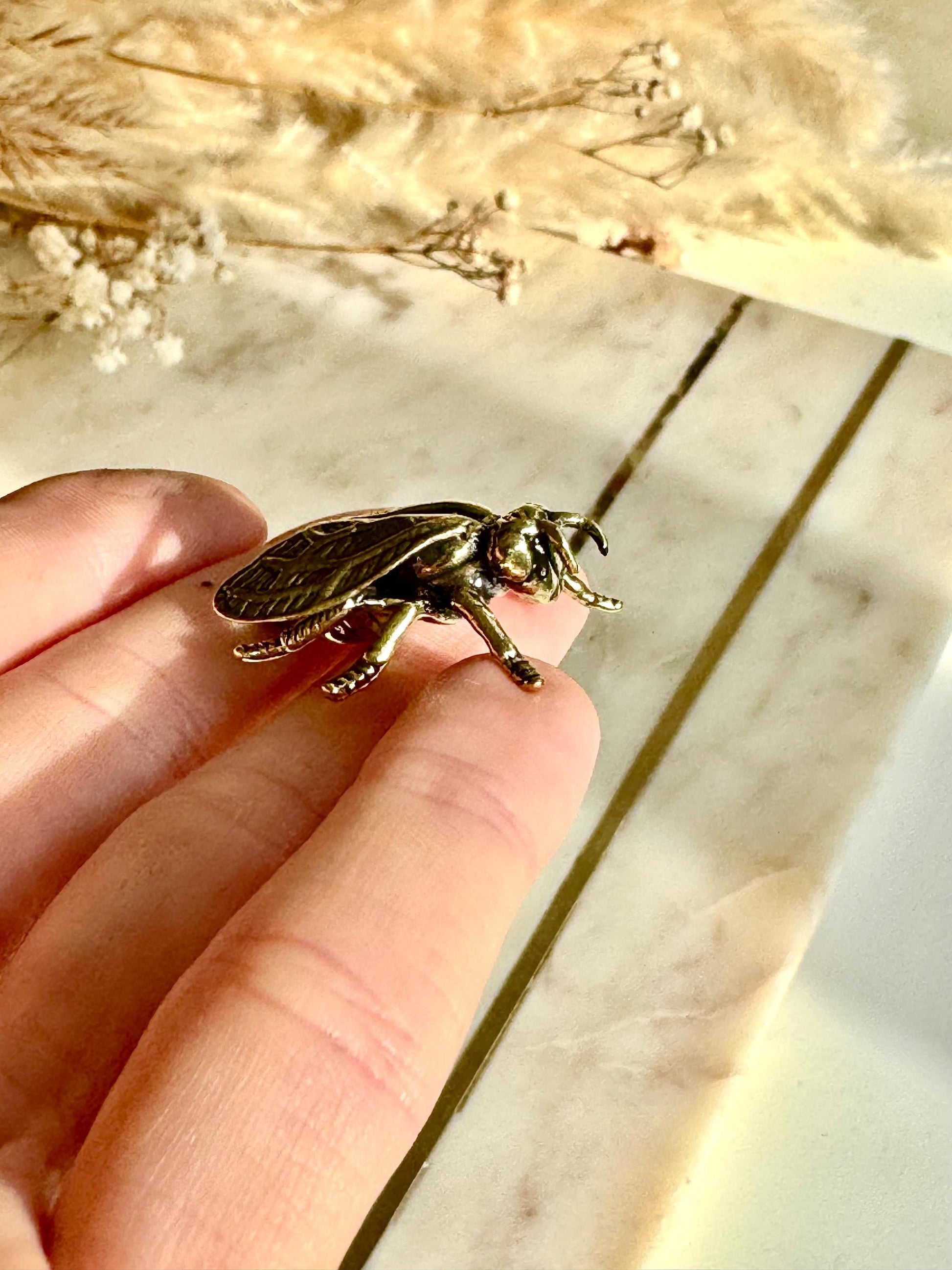 Solid brass bee figurine, realistic fly sculpture, metal insect ornament, detailed brass flying bug paperweight.