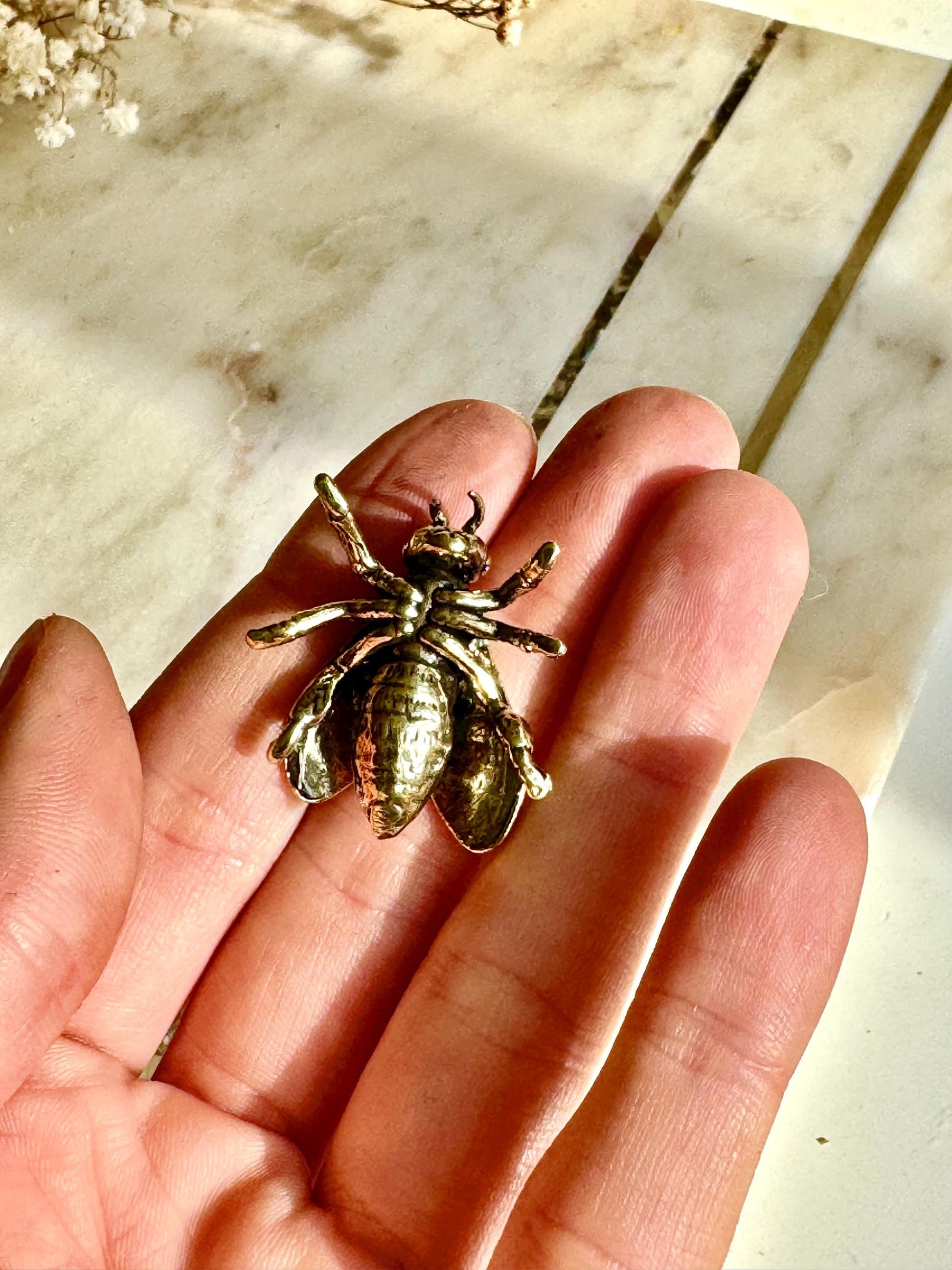 Solid brass bee figurine, realistic fly sculpture, metal insect ornament, detailed brass flying bug paperweight.