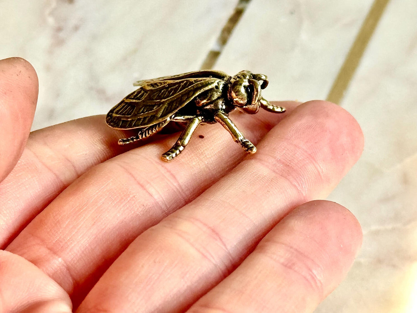 Solid brass bee figurine, realistic fly sculpture, metal insect ornament, detailed brass flying bug paperweight.