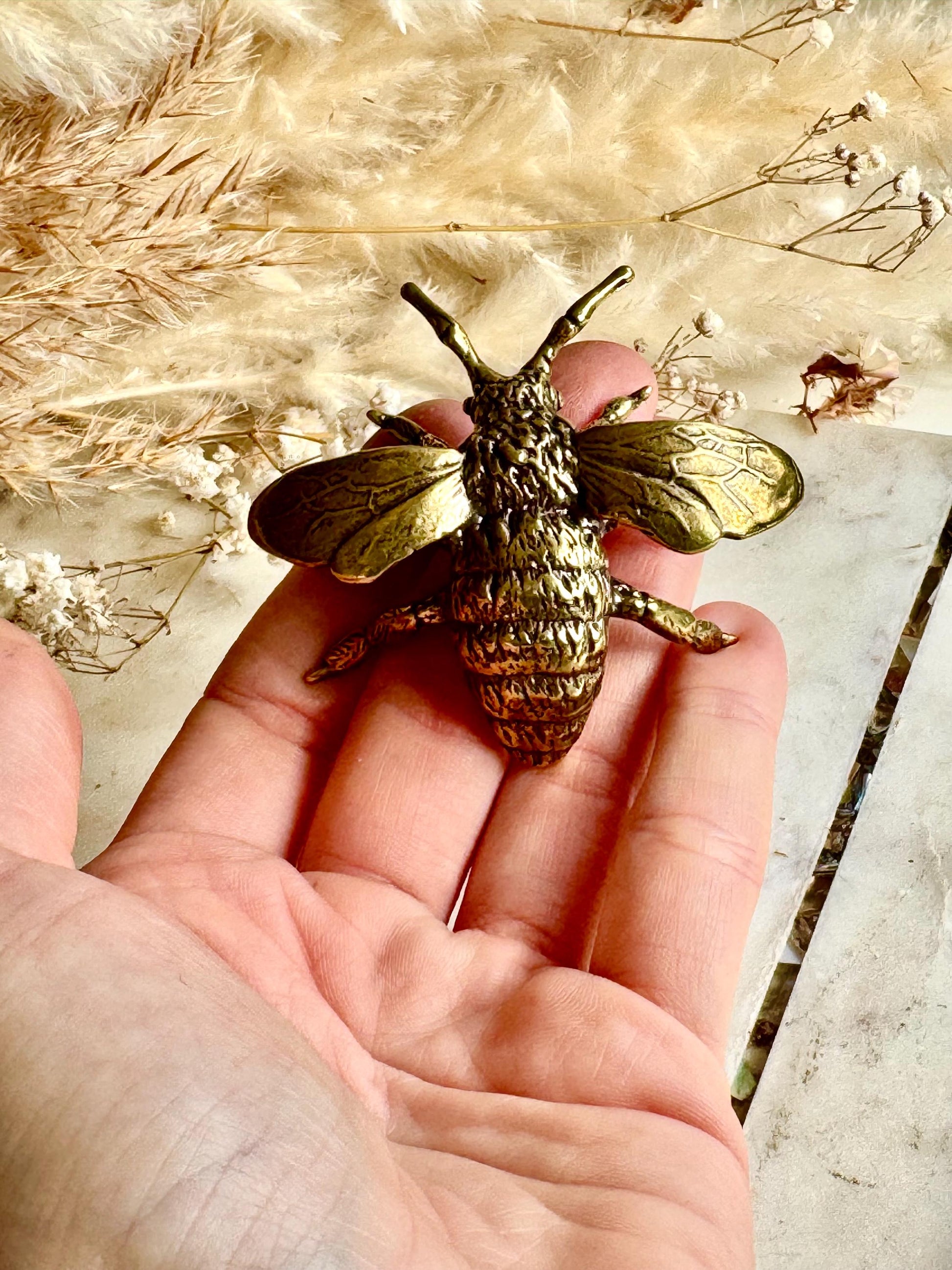 Solid brass bumblebee figurine, realistic bee sculpture, insect ornament, detailed brass garden pollinator paperweight.